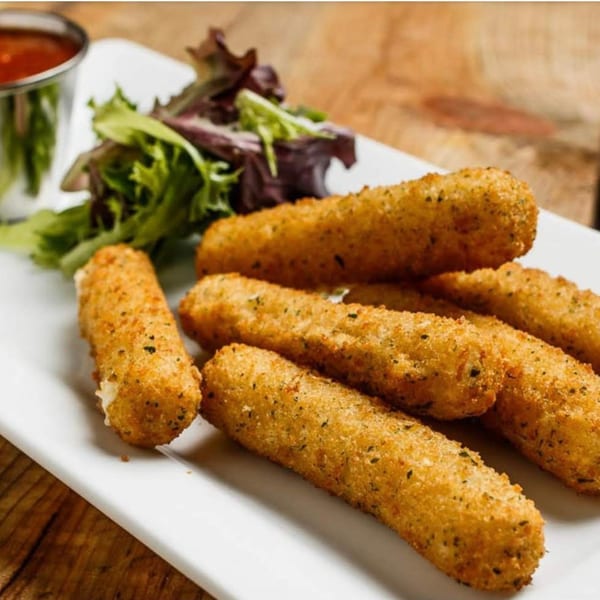 Golden-brown mozzarella sticks with herbs, served with a side salad and dipping sauce on a white plate.