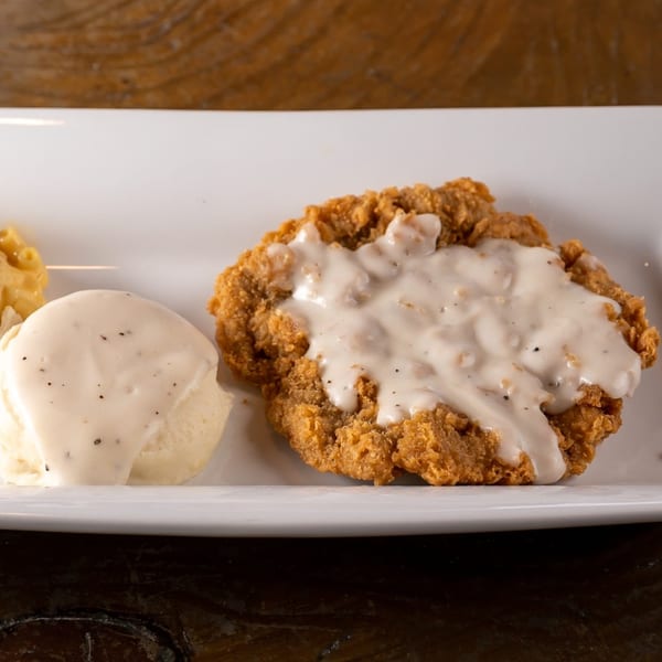 Crispy fried chicken steak smothered in white gravy, served with mashed potatoes and macaroni and cheese.